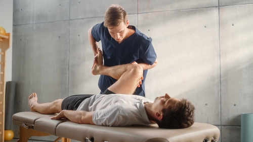 Clinician assisting a patient with a rehabilitation stretch